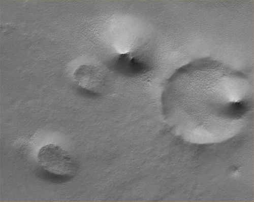 Hills, Knobs and Buried Craters in the South Polar Region (Original NASA/MGS/MSSS b/w Frame)
Original caption:"This MGS-MOC image shows a Summer scene from the South Polar Region of Mars. The circular feature in the North-East (upper right) corner of the image is an old meteor impact crater that has been partially filled and buried. The cone-shaped hill that occurs within the crater on its East (right) side is a remnant of material that once covered and completely buried the crater. Perhaps beneath the surfaces in the rest of the image there are other craters that have been filled and buried such that we cannot know, from an image, that they ever existed. The theme of filled, buried, and exhumed craters is one that repeats itself —over and over again — all over Mars".

Location near: 80,3° South Lat. and 286,1° West Long.  
Image width: ~3 Km (~1,9 mi)  
Illumination from: upper left  
Season: Southern Summer
Parole chiave: Mars from orbit - South Polar Features - Hills & Knobs