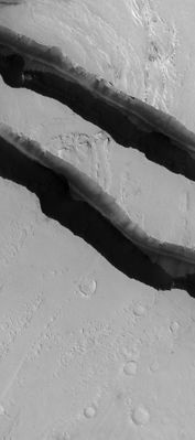 What's inside the Trough? (CTX Frame - Original NASA/MGS/MSSS b/w Frame)
Caption NASA originale:"This MGS-MOC image shows Channels carved by catastrophic Floods in the Tharsis Region of Mars. This area is located North/West of Jovis Tholus, and East of the large Martian Volcano Olympus Mons. The Terrain is presently mantled with fine Dust". 

Location near: 10,5° North Lat. and 203,4° West Long.
Image width: width: ~3 Km (~1,9 mi) 
Illumination from: lower left 
Season: Northern Autumn
Parole chiave: Mars from orbit - Troughs and Canyons