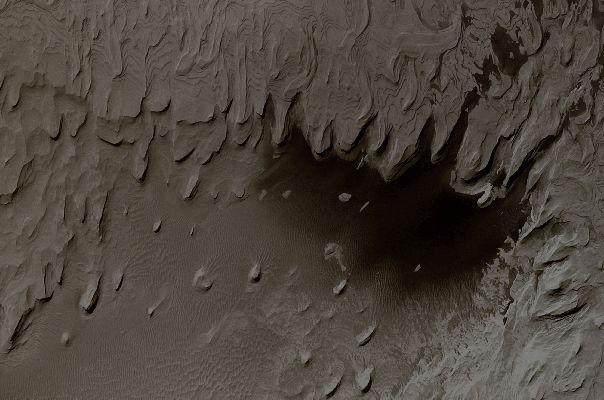 Layers in Schiaparelli Crater (Natural Colors; credits: Lunexit)
Da "NASA - Picture of the Day", del giorno 29 Novembre 2009:"Is this a picture of Mars or Earth? 
Oddly enough, it is a picture of Mars. What may appear to some as a terrestrial coastline is in fact a formation of ancient layered hills and wind-blown sand on Mars. 
The above-pictured region spans about 3 Km in Schiaparelli Crater. What created the layers of sediment is still a topic of research. Viable hypotheses include ancient epochs of deposit either from running water or wind-blown sand. Winds and sandstorms have smoothed and eroded the structures more recently. 
The "water" that appears near the bottom is actually dark colored sand. The image was taken with the Mars Global Surveyor Spacecraft that operated around Mars from 1996-2006 and returned over 200.000 images".
Parole chiave: Mars from orbit - Craters - Schiaparelli Crater