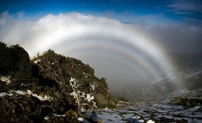 Glory never fades...
If you tried to enter this hall of fog, you would find it dissipates around you. The hall is actually an the mountain from which this picture was taken. 
Known as "The Glory", the phenomenon is frequently seen from airplanes. The ring's center is not visible, but if it were, the shadow of the observer would appear. This shadow would likely change as clouds passed, creating a faux moving giant known as the Brocken Spectre. 

Pictured above, several concentric rings of the glory appear to create a hall for this mountain king. The cause of The Glory has only been understood recently and is relatively complex. Briefly, small droplets of water reflect, refract, and diffract Sunlight backwards towards the Sun. The phenomenon has a counterpart in astronomy, where looking out from planet Earth in the direction opposite the Sun yields a bright spot called "The Gegenschein".
Parole chiave: Artistic Pictures